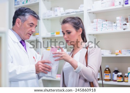 Pharmacist explaining medicine to his customer in the pharmacy