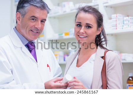 Pharmacist and customer looking at camera in the pharmacy