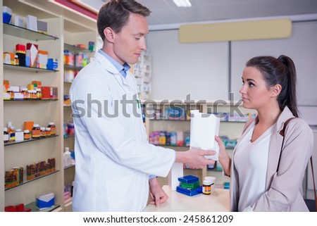 Pharmacist giving a bag of drugs to his sick client in the pharmacy