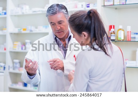Pharmacist speaking with cheerful young customer in the pharmacy