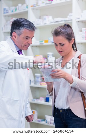 Pharmacist explaining medicine to his customer in the pharmacy