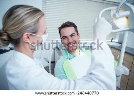 Female dentist examining mans teeth in the dentists chair