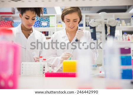 Pretty science students using pipette at the university