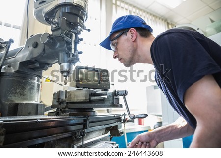 Engineering student using large drill at the university