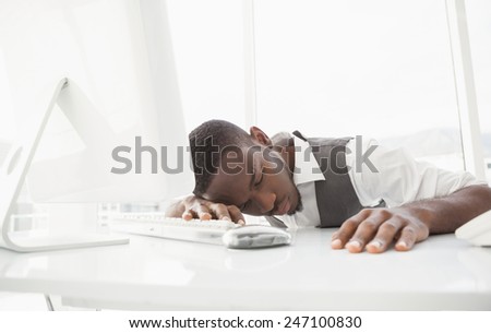 Tired businessman sleeping on keyboard in his office