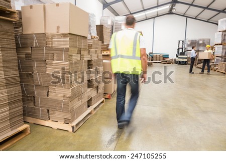 Blurred manual worker walking in the warehouse