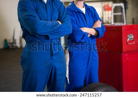 Team of mechanics standing with arms crossed at the repair garage