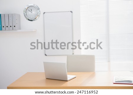 A empty lighted office with a laptop