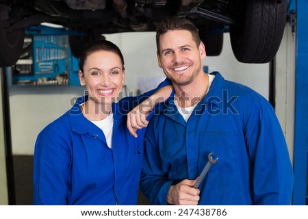 Team of mechanics smiling at camera at the repair garage