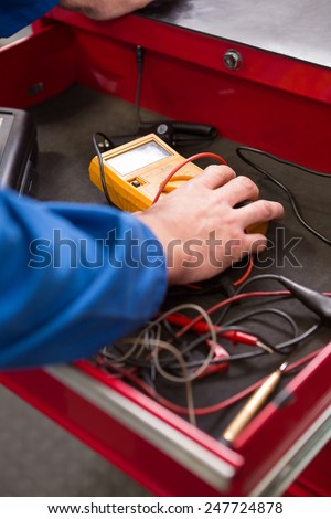 Mechanic taking a diagnostic tool from drawers at the repair garage