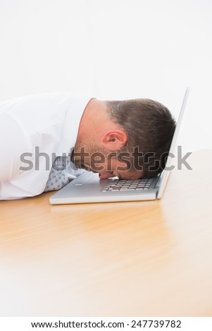Business man sleeping put his head in his computer at his desk
