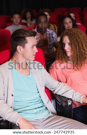 Young couple watching a film at the cinema