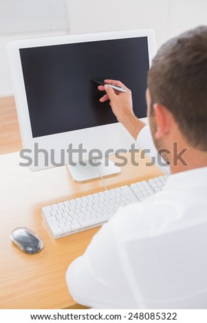 Businessman using a graphic tablet and a computer monitor at his desk