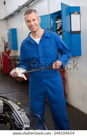 Mechanic checking the oil of car at the repair garage