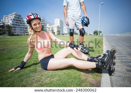 Fit couple getting ready to roller blade on a sunny day
