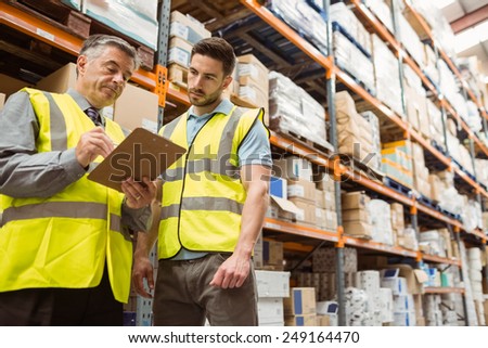 Warehouse manager speaking with foreman in a large warehouse