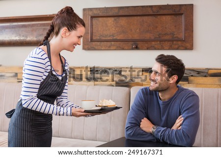 Waitress bringing man coffee and tart at the cafe