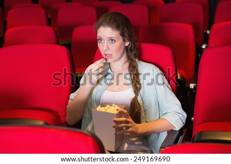 Young woman watching a film at the cinema