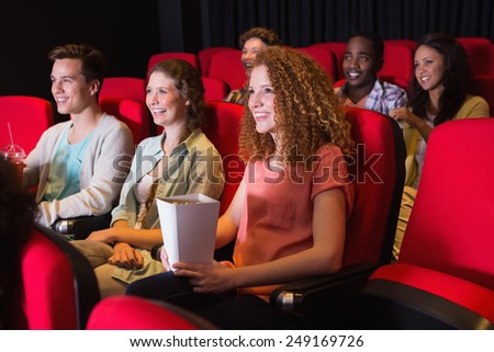 Young friends watching a film at the cinema