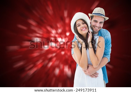 Happy hipster couple smiling at camera against valentines heart design