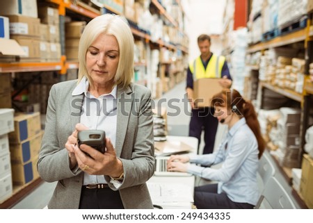 Focused warehouse manager using handheld in a large warehouse
