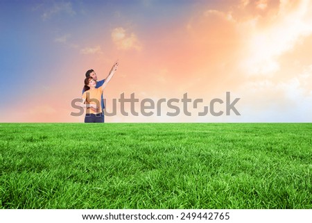 Happy couple pointing upwards together against desert landscape
