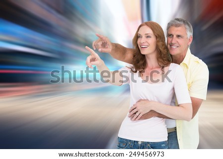 Casual couple smiling and pointing against blurry new york street