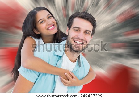 Happy casual man giving pretty girlfriend piggy back against love heart pattern