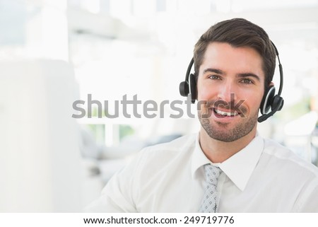 Handsome businessman with headset interacting in his office
