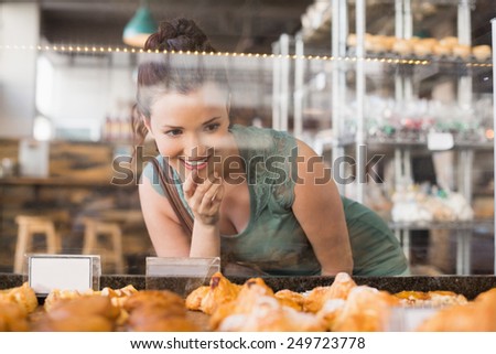Pretty brunette looking at pastrys at the bakery