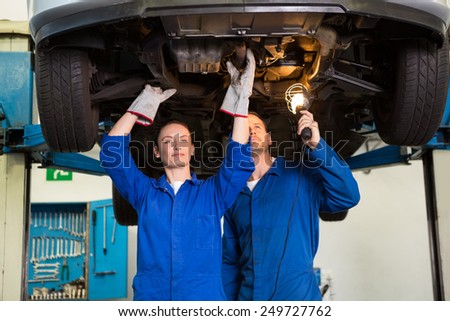 Team of mechanics working together at the repair garage