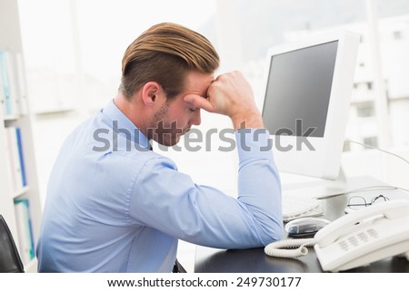 Tired businessman working with computer in his office