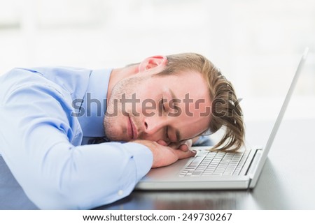 Businessman sleeping on his laptop in the office