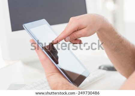 Hand of businessman using tablet at desk in his office