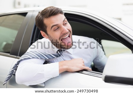 Carefree businessman sitting in drivers seat in his car