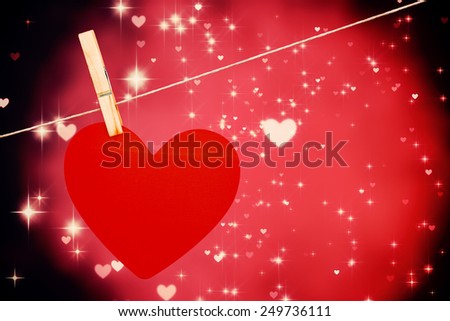 Heart hanging on line against valentines heart design