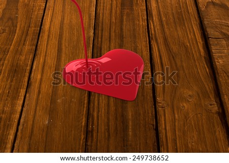 Liquid heart pouring against overhead of wooden planks
