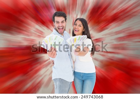 Happy couple showing their money against love heart pattern