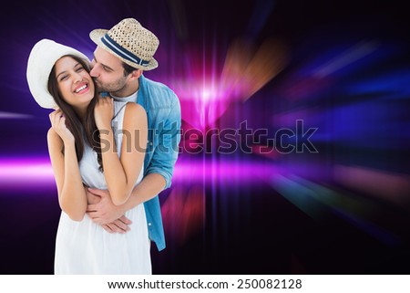 Happy hipster couple hugging and smiling against digitally generated cool nightlife design with hearts