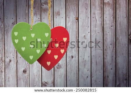 Cute heart decorations against digitally generated grey wooden planks