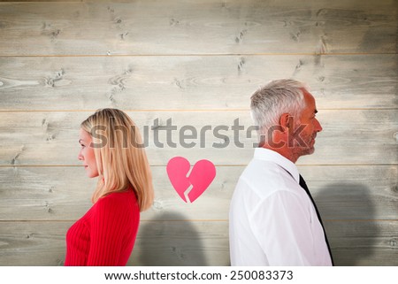 Couple not talking with broken heart between them against bleached wooden planks background