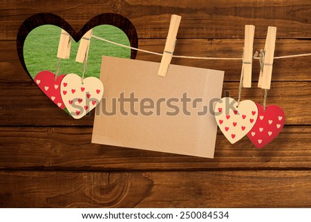 Hearts hanging on line with card against heart in wood