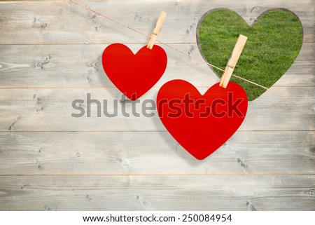 Hearts hanging on a line against heart in wood