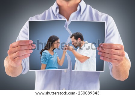 Angry couple pointing at each other against grey vignette