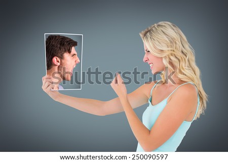 Angry young man with stubble shouting against grey vignette