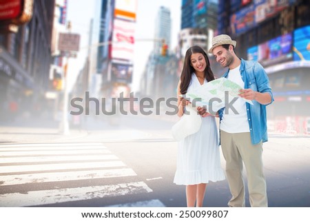 Happy hipster couple looking at map against blurry new york street