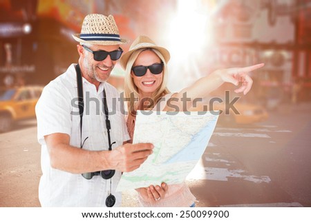 Happy tourist couple using map and pointing against blurry new york street