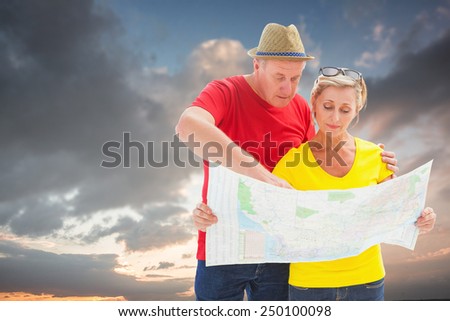 Lost tourist couple using map against blue and orange sky with clouds