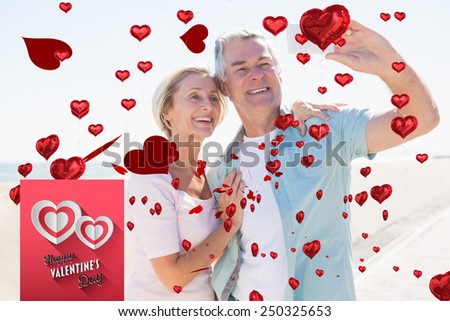 Happy senior couple posing for a selfie against happy valentines day