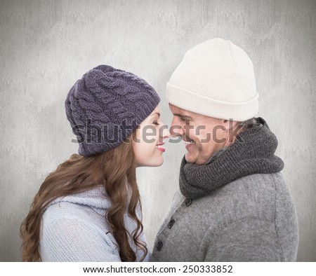 Couple in warm clothing facing each other against white background
